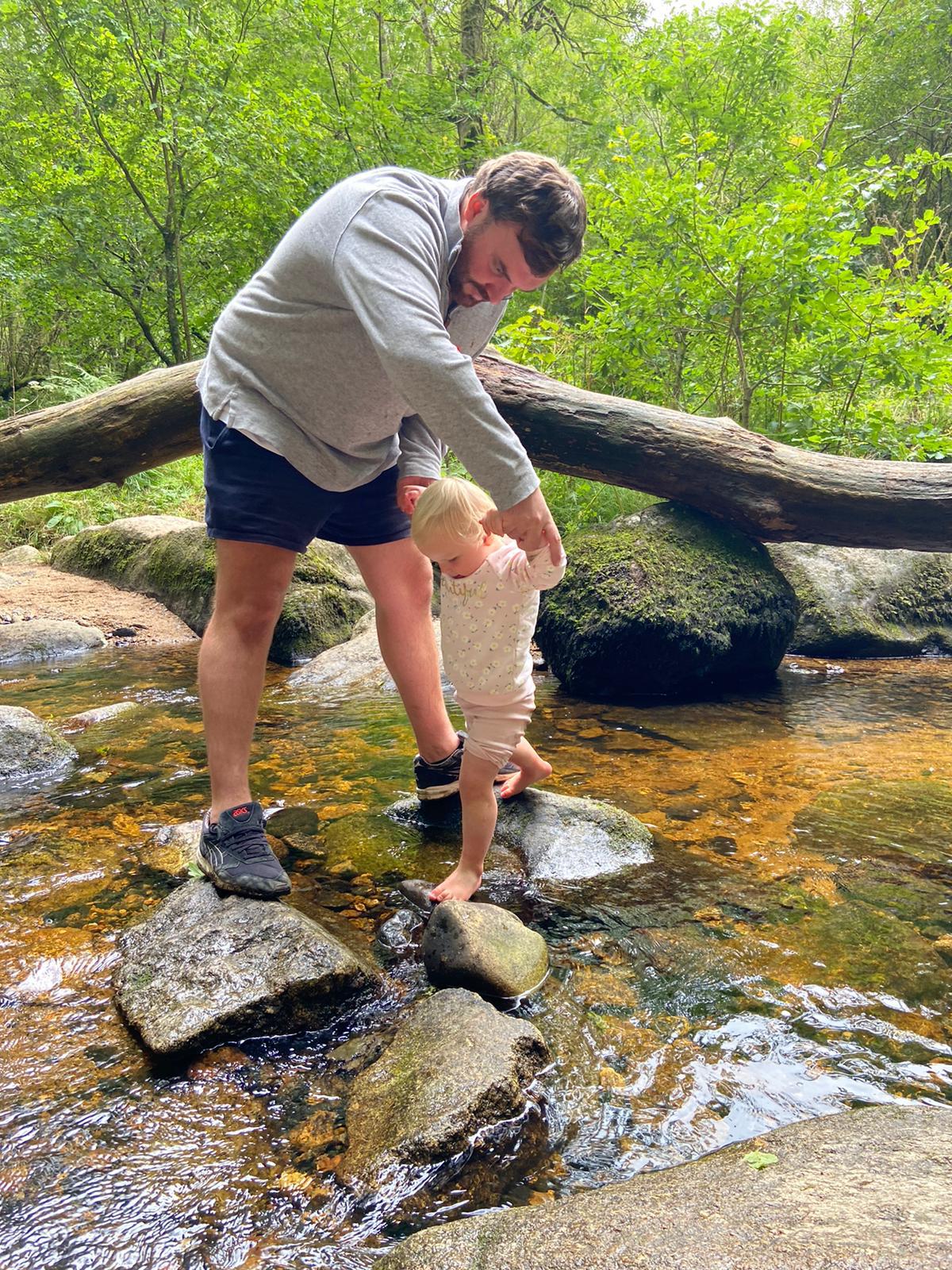 Dad helping toddler over stepping stones
